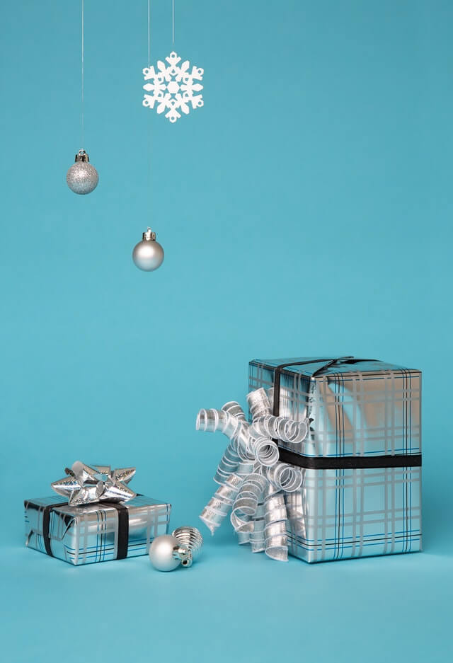 to gaver pakket ind i glimtende sølv papir med sølvfarvet bånd omkring